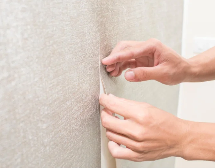 Pose de papier peint intissé : ajustement du lé et du raccord sur un mur